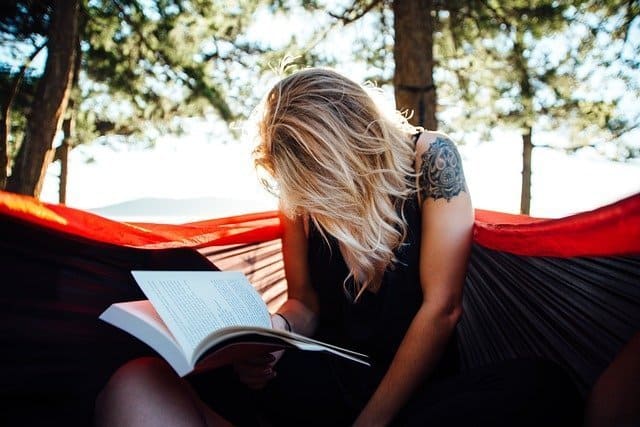 Una mujer leyendo un título de una lista de libros recomendados para empezar bien el año